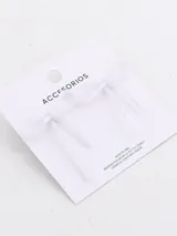Par de caravanas con forma de moño confeccionadas en tela blanca traslúcida con detalles brillantes.