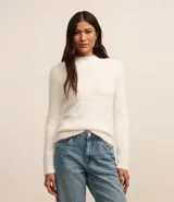 Suéter de punto color blanco, con cuello alto y mangas largas, confeccionado en tejido de peluche.