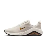 Championes Nike Bella 7 de mujer, color crema con logo dorado.