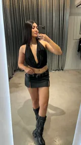 Top negro con escote drapeado tipo halter y espalda descubierta.