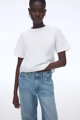 Remera blanca de manga corta con cuello redondo y hombros ligeramente caídos.