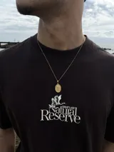 Cadena dorada con dije ovalado de San Miguel Arcángel.