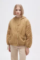 Campera negra de manga larga con capucha, cierre frontal con botones a presión, bolsillos laterales y cordón ajustable en la cintura.