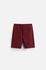 Bermuda negra de corte relaxed fit, con cintura elástica ajustable con cordón, bolsillos frontales y bolsillo trasero de parche.