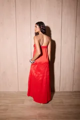 Vestido largo strapless de tafeta color rojo con efecto tornasolado, corte suelto y bolsillos ocultos.