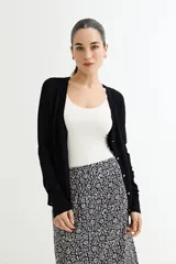 Cárdigan negro de tejido de punto fino con escote en V, cierre frontal con botones dorados y mangas largas con puños ajustados.