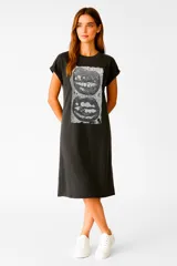 Vestido midi negro de algodón con estampado de dos bocas en blanco y negro. Tiene cuello redondo, mangas cortas con dobladillo y corte holgado.