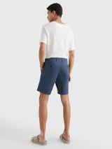 Bermuda azul de corte recto confeccionada en algodón elástico. Cuenta con dos bolsillos delanteros en diagonal y dos bolsillos traseros de ojal con botón.