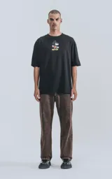 Remera negra de manga corta con cuello redondo y calce oversize. Estampado frontal de Mickey Mouse andando en skate.