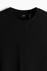 Remera negra de corte estándar con cuello redondo ribeteado y bajo recto. Confeccionada con tejido funcional COOLMAX®, una fibra de poliéster de secado rápido que elimina la humedad y regula la temperatura corporal.