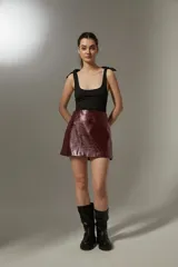 Minifalda de cuero sintético color borgoña, de tiro alto y corte al cuerpo.