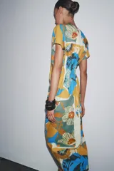 Vestido midi de algodón con estampado floral multicolor, cuello redondo, manga corta caída y pliegues en la cintura.