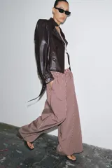 Pantalón de tiro medio con cintura elástica y bolsillos laterales ocultos en costura. Pierna ancha y estampado a rayas verticales color borgoña y blanco.
