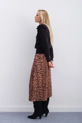 Falda midi plisada con estampado animal print de cebra en tonos beige y marrón. Tiene cintura elástica.