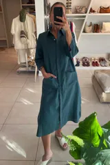 Vestido camisero midi color verde azulado, de lino, con cuello camisero, manga tres cuartos y bolsillos laterales.