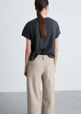 Remera negra de algodón con cuello redondo y mangas cortas. Estampado frontal con la frase "Evolve & Grow" y diseño de mariposas en color blanco.