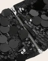 Conjunto de dos piezas, top tipo bandeau y mini falda, ambos completamente cubiertos de lentejuelas negras.