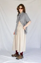 Falda midi color beige de microfibra con cintura elastizada y frunces laterales.