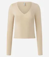 Suéter de punto color beige, con escote en V y mangas largas.
