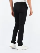 Pantalón de vestir negro, corte slim, con cierre de botón y cremallera.