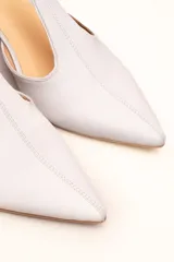 Sandalia de cuero color bordó, con acabado charolado, punta fina y tacón cuadrado de 5 cm. Presenta una tira en forma de T sobre el empeine y una correa con hebilla alrededor del tobillo.