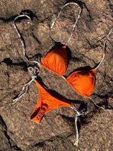 Conjunto de bikini con estampado animal print blanco y negro. El corpiño es de triángulos movibles con tiras finas para atar al cuello y a la espalda, con almohadillas desmontables. La bombacha es colaless con tiras finas para atar a los costados.