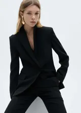 Traje sastrero rojo compuesto por blazer de corte recto con solapas de muesca y cierre de doble botón, chaleco con escote en V y pantalón de vestir de corte recto.