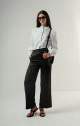 Camisa de manga larga color celeste con finas rayas verticales oscuras. Presenta cuello mao con volados y un detalle de volado vertical en el centro frontal. Las mangas tienen un ligero efecto globo en los hombros.