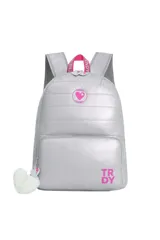 Mochila acolchada color plateado brillante con correas ajustables y detalles en rosa. Presenta un bolsillo frontal con cierre y un dije de pompón blanco colgante. El logo 'TRDY' está impreso en la parte inferior frontal.