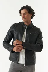 Campera de cuero sintético negra con cuello mao, cierre frontal con cremallera, bolsillos laterales con cremallera y detalle de costuras en los hombros.