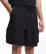 Bermuda cargo color hueso, con cintura elástica ajustable con cordón, bolsillos laterales tipo cargo con cierre y bolsillos laterales y traseros.