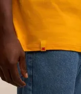 Remera amarilla de algodón con cuello redondo y mangas cortas. Estampado frontal con el logo de Kodak y un rollo de película.