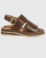 Sandalia de cuero color marrón chocolate, con tira ancha sobre el empeine, hebilla dorada al tobillo y suela track.