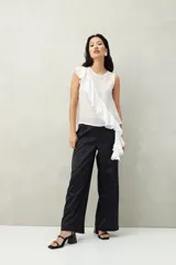 Top blanco de tencel sin mangas, de corte asimétrico, con volados en diagonal.