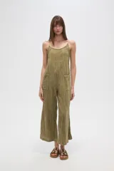 Mono de algodón negro, estilo lencero, con tirantes finos, escote en V y bolsillos frontales. El calce es holgado y presenta un cordón ajustable en la cintura.