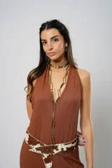 Mono largo color marrón con textura, escote halter, corte holgado, cinturón de cuero con estampado animal y cierre frontal con botones.