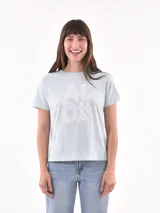 Remera celeste con estampado de letras blancas y una palmera.