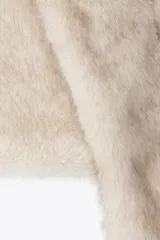 Bufanda de pelo sintético color beige con diseño cruzado.