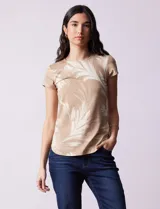 Remera de modal color beige con estampado de hojas blancas, cuello redondo y mangas cortas.