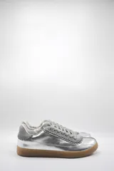 Zapatillas bajas plateadas de cuero con detalles de gamuza gris y suela de goma color caramelo.