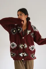 Saco tejido a mano de lana color azul marino con diseño geométrico multicolor. Tiene cuello tipo chal y cierre frontal con botones.