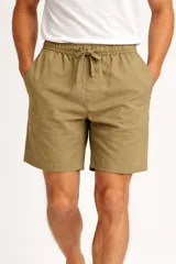 Short de lino color verde militar, con cintura elástica y cordón ajustable. Cuenta con bolsillos laterales y un corte ancho.