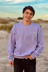Buzo lila de corte oversize con cuello redondo y estampado en la espalda con el logo de la marca.