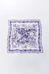 Pañuelo cuadrado de tela fina color blanco con estampado de flores y aves en tonos de azul y violeta.