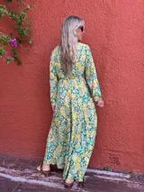 Vestido largo de seda con escote en V y mangas largas amplias. Presenta un estampado tipo cachemir o mandala en tonos verde, amarillo y blanco/crudo.