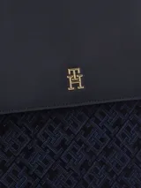 Mochila Tommy Hilfiger azul con monograma TH en jacquard, asa superior, cierre de solapa, compartimento principal, correas ajustables y logo metalizado en la parte delantera. Fabricada en poliéster reciclado.