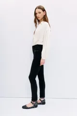 Jean slim tiro medio-alto, color negro, calce al cuerpo, pierna semi-recta y detalle de hotfix en bolsillos.