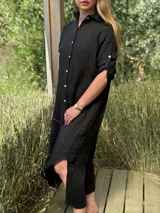 Vestido camisero largo de lino blanco, con corte en la cintura, abertura lateral y botones de nácar.