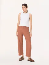 Pantalón color ladrillo de corte slouchy con cinco bolsillos y pinzas en las rodillas que estructuran la silueta con un aire urbano. Incluye metales en acabado níquel.