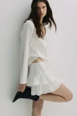 Minifalda blanca con bordado de flores y tres volados escalonados.